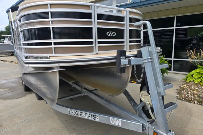 Slide: The Image of 2017 Harris Solstice 240 pontoon boat on a trailer, parked outside a building. - 13