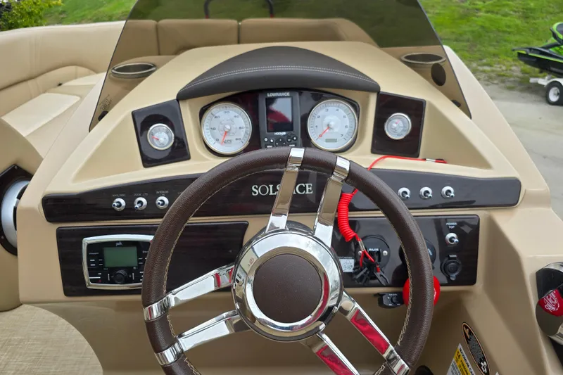 Slide: The Image of 2017 Harris Solstice 240 boat dashboard with steering wheel and control gauges. - 30