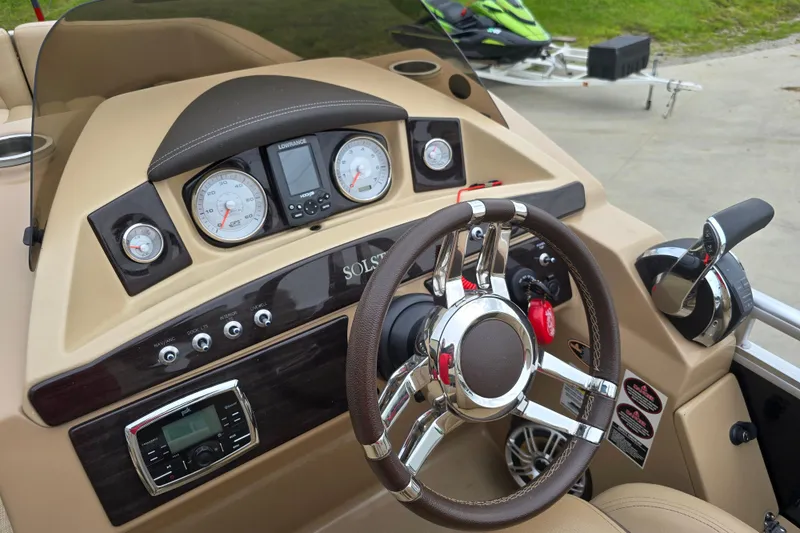 Slide: The Image of 2017 Harris Solstice 240 boat dashboard with steering wheel and control panel. - 6