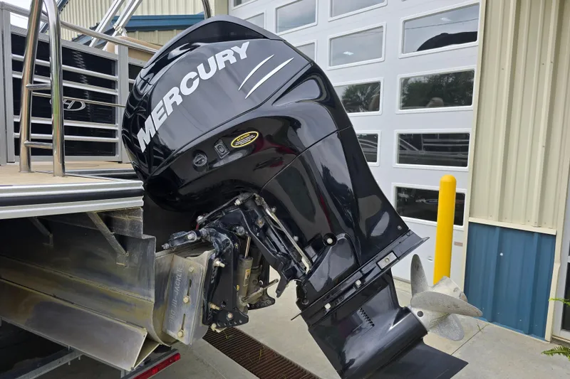 Slide: The Image of 2017 Harris Solstice 240 with Mercury outboard motor, docked near a building. - 8