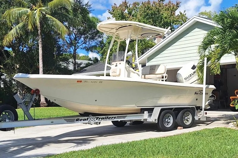 The Image of 2018 Sea Chaser 21 LX boat on trailer, parked in a tropical driveway. - 0