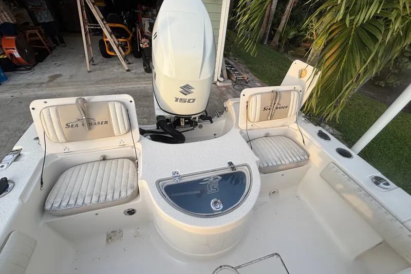 Slide: The Image of 2018 Sea Chaser 21 LX boat interior with Suzuki 150 engine, featuring seating and storage. - 13