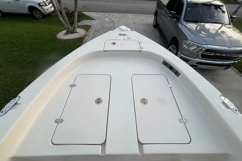 Slide: The Image of 2018 Sea Chaser 21 LX boat deck with storage compartments, parked near driveway. - 15