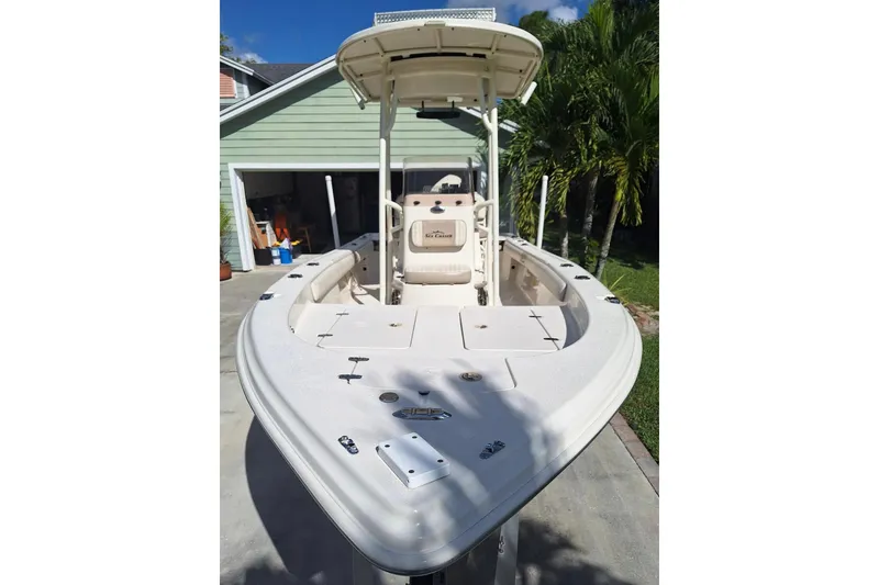 Slide: The Image of 2018 Sea Chaser 21 LX boat in driveway, featuring spacious deck and T-top. - 2