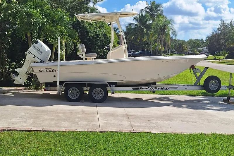 Slide: The Image of 2018 Sea Chaser 21 LX boat on trailer, parked in a sunny driveway. - 4