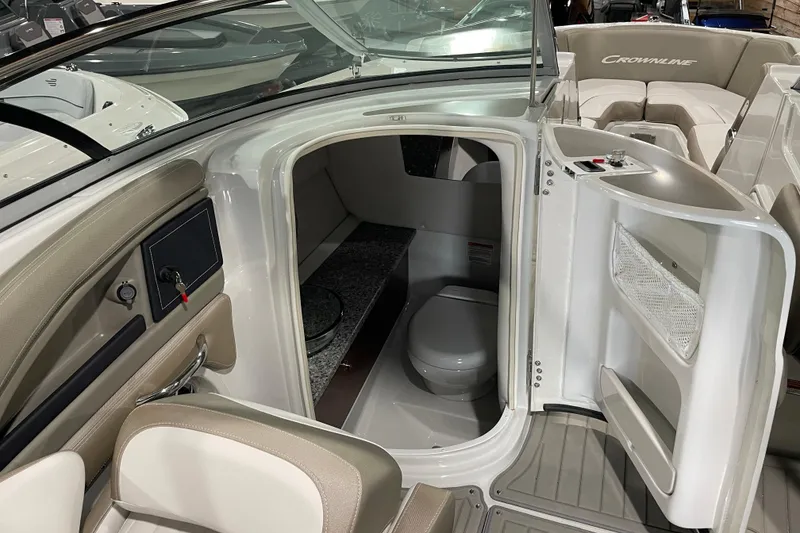 Slide: The Image of 2026 Crownline 260 SS boat interior with compact bathroom and seating area. - 19