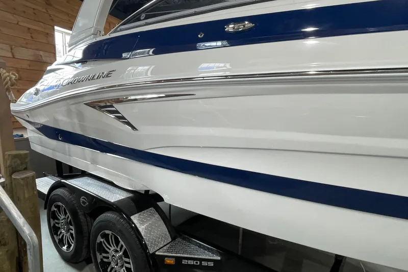 Slide: The Image of 2026 Crownline 260 SS boat on trailer, sleek design with blue and white accents. - 9