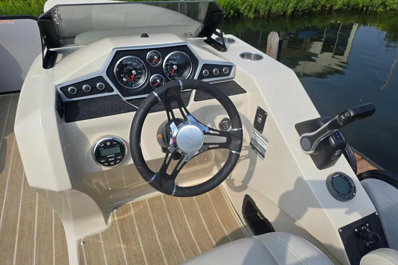 Slide: The Image of 2019 Manitou 21 Oasis RF boat dashboard with steering wheel and control panel. - 20