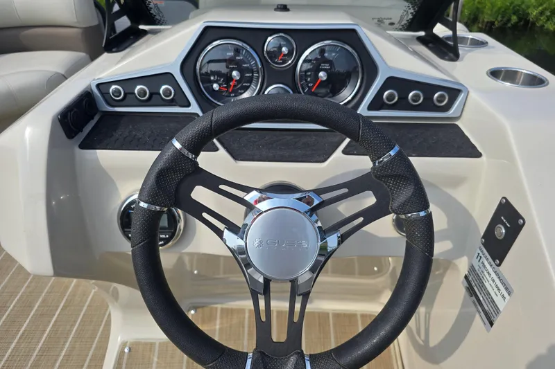 Slide: The Image of Steering wheel and dashboard of 2019 Manitou 21 Oasis RF boat. - 21