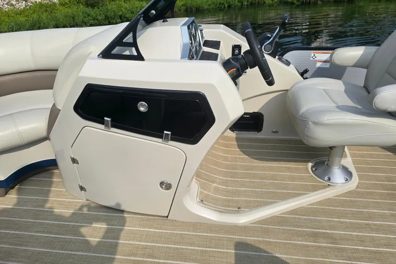 Slide: The Image of 2019 Manitou 21 Oasis RF boat interior with steering console and seating. - 22