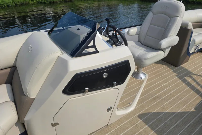 Slide: The Image of 2019 Manitou 21 Oasis RF boat interior with steering console and seating. - 23