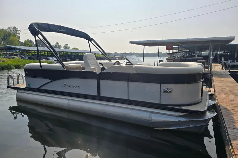 Slide: The Image of 2019 Manitou 21 Oasis RF pontoon boat docked on calm water. - 3
