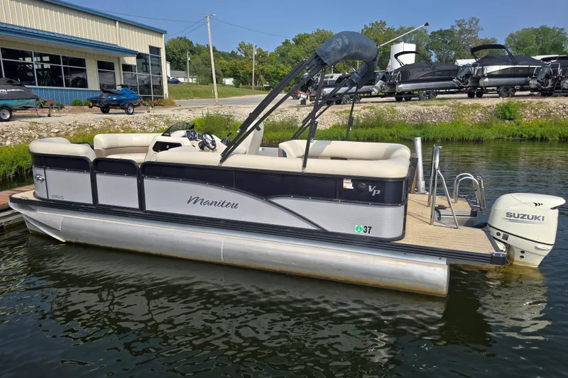 Slide: The Image of 2019 Manitou 21 Oasis RF pontoon boat with Suzuki outboard motor docked by a marina. - 5