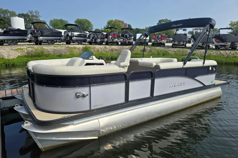 Slide: The Image of 2019 Manitou 21 Oasis RF pontoon boat docked on calm water. - 9