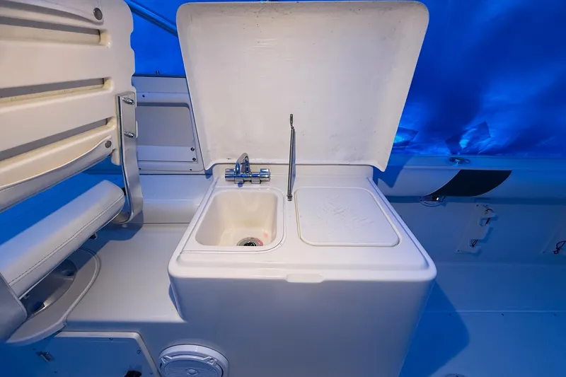Slide: The Image of 1998 Pursuit 2860 Denali boat sink with open lid and faucet. - 15