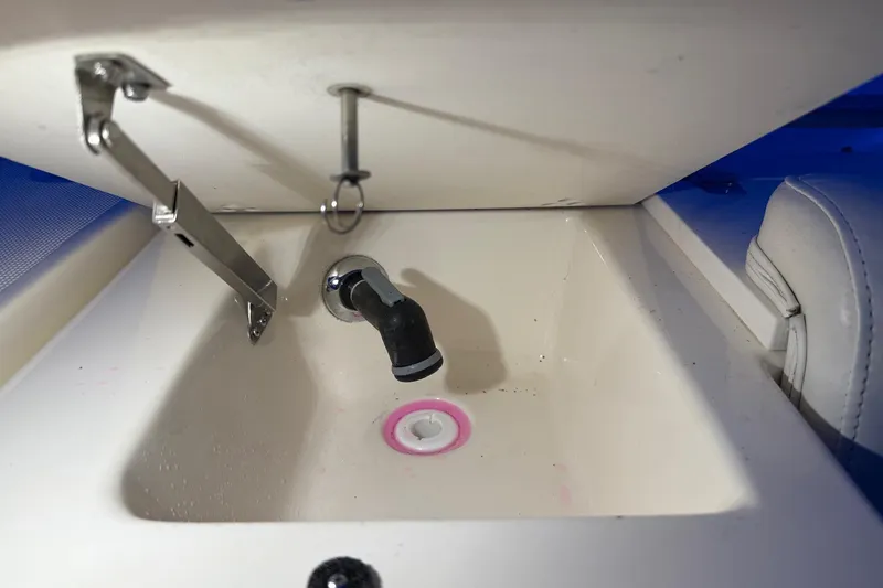 Slide: The Image of 1998 Pursuit 2860 Denali boat sink with open lid and visible plumbing. - 16