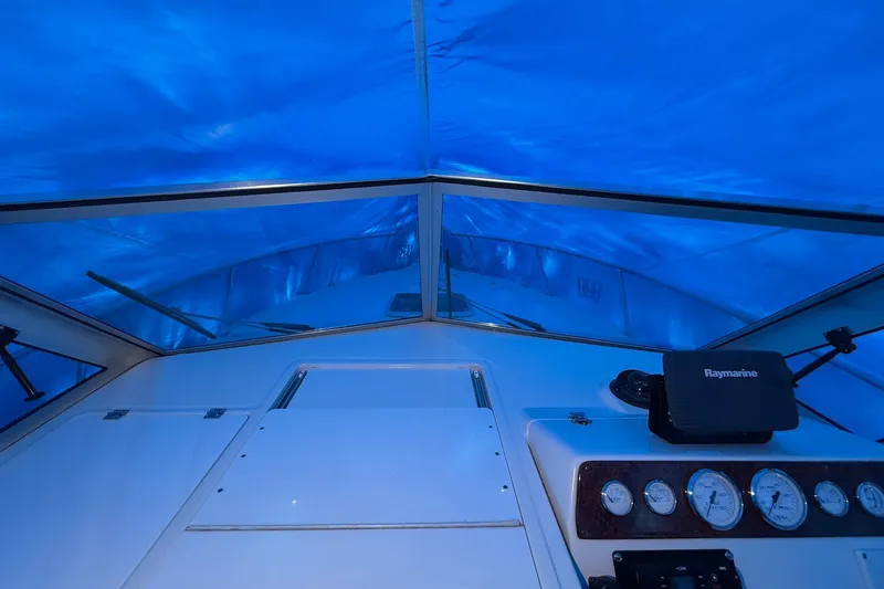 Slide: The Image of 1998 Pursuit 2860 Denali boat cockpit with blue tarp cover and Raymarine equipment. - 19