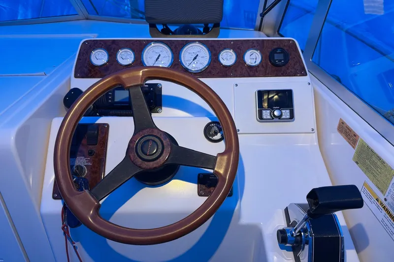 Slide: The Image of 1998 Pursuit 2860 Denali boat dashboard with steering wheel and gauges. - 21