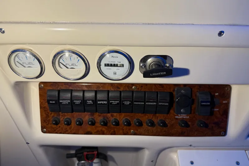 Slide: The Image of 1998 Pursuit 2860 Denali dashboard with fuel gauges and control switches. - 24
