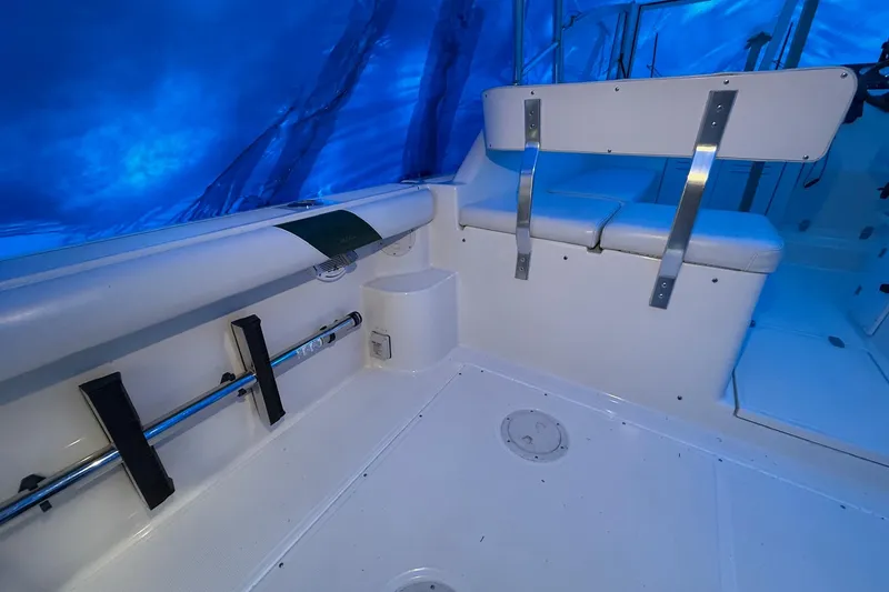 Slide: The Image of Interior of a 1998 Pursuit 2860 Denali boat with white seating and blue canopy. - 27