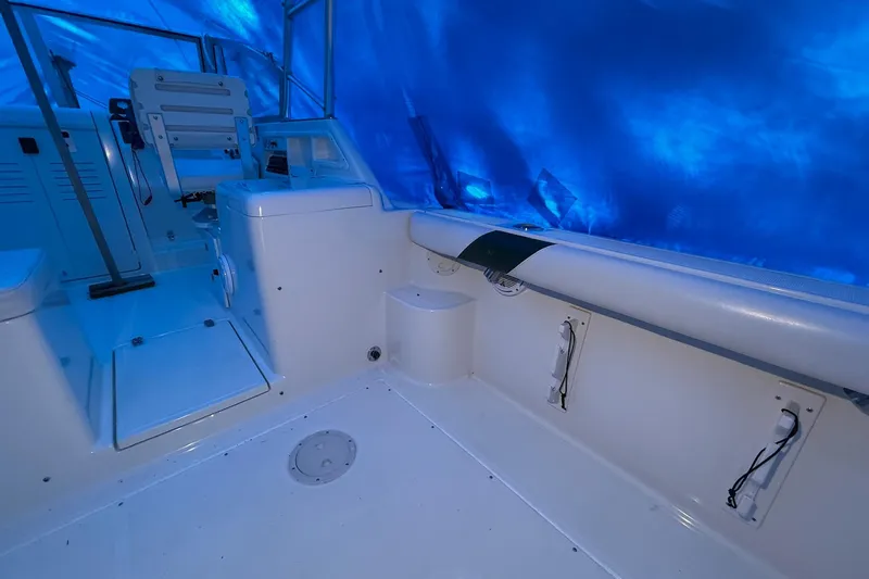 Slide: The Image of 1998 Pursuit 2860 Denali boat interior with seating and blue tarp cover. - 29