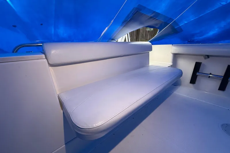 Slide: The Image of 1998 Pursuit 2860 Denali boat interior with white seating under blue cover. - 30