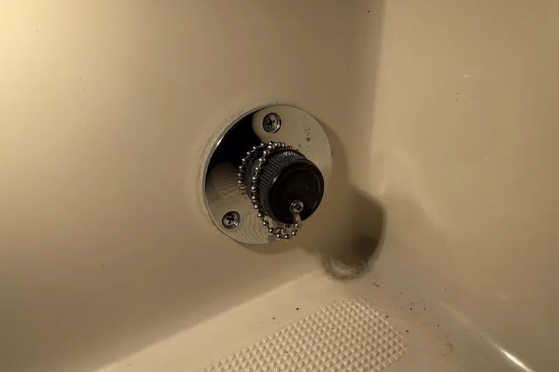 Slide: The Image of Close-up of a 1998 Pursuit 2860 Denali boat drain plug with chain attachment. - 32