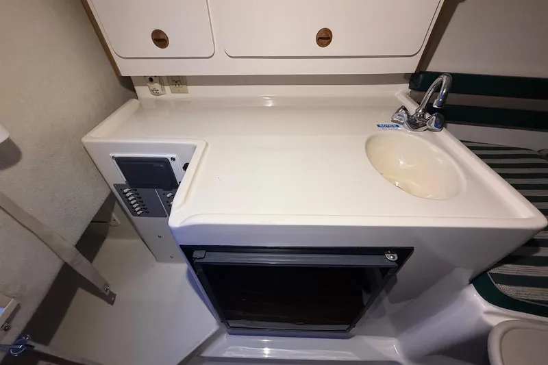 Slide: The Image of 1998 Pursuit 2860 Denali boat interior with sink and storage cabinets. - 36