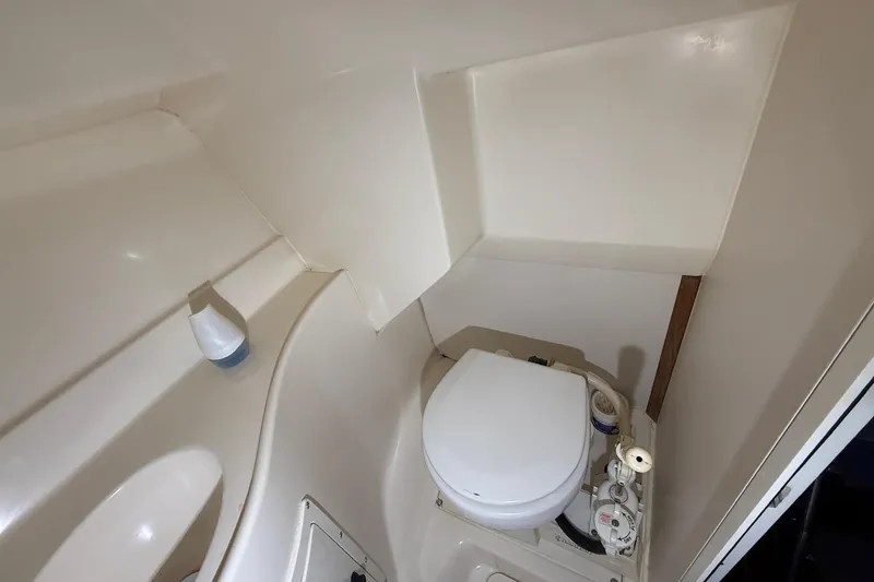 Slide: The Image of 1998 Pursuit 2860 Denali boat bathroom with compact toilet and sink. - 39