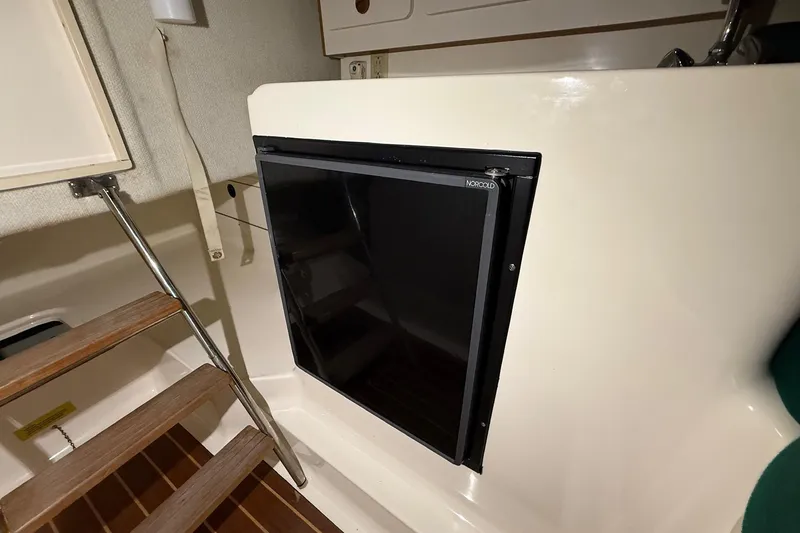 Slide: The Image of 1998 Pursuit 2860 Denali cabin interior with Norcold refrigerator and wooden steps. - 44