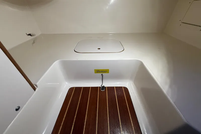 Slide: The Image of 1998 Pursuit 2860 Denali boat interior with wooden flooring and storage compartment. - 45