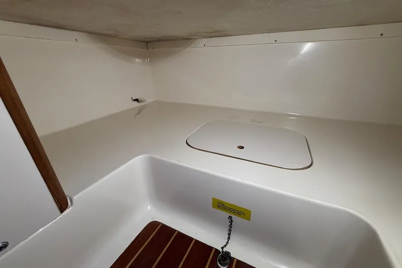 Slide: The Image of 1998 Pursuit 2860 Denali boat interior with white surfaces and wooden flooring. - 46