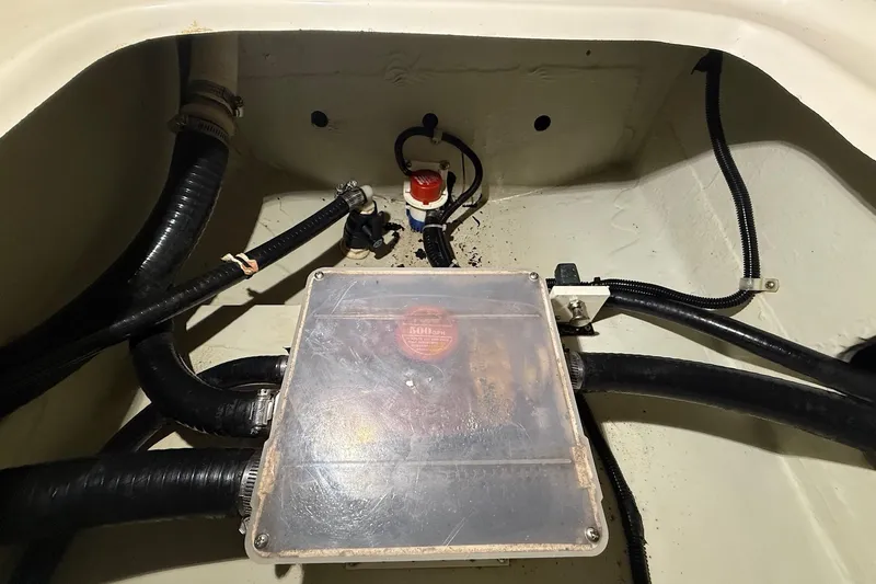 Slide: The Image of 1998 Pursuit 2860 Denali boat engine compartment with hoses and wiring. - 48