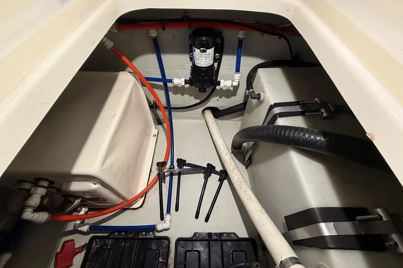 Slide: The Image of 1998 Pursuit 2860 Denali boat interior showing plumbing and wiring components. - 49
