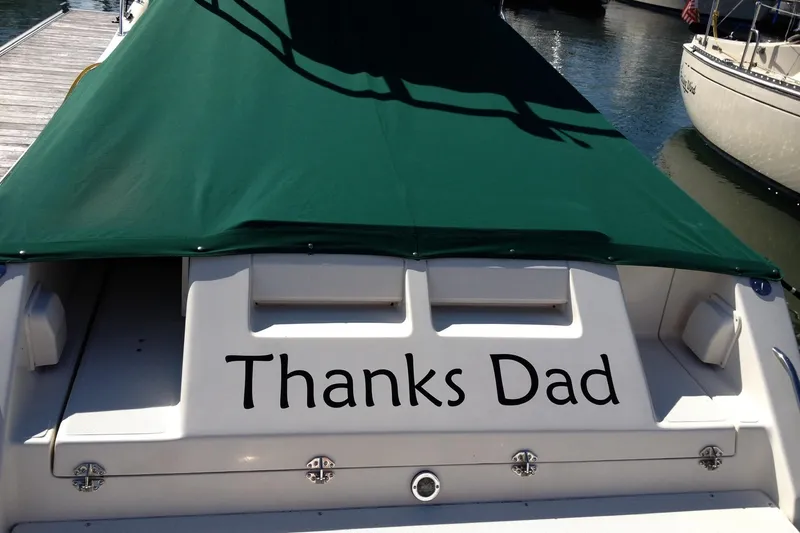 Slide: The Image of 1998 Pursuit 2860 Denali boat with green cover, "Thanks Dad" text on stern. - 5