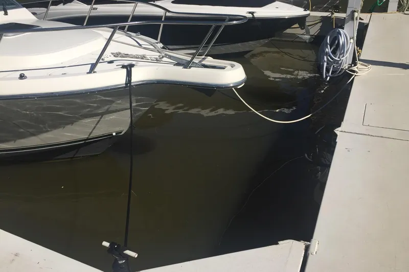 Slide: The Image of 1998 Pursuit 2860 Denali boat docked at marina with water reflections. - 9