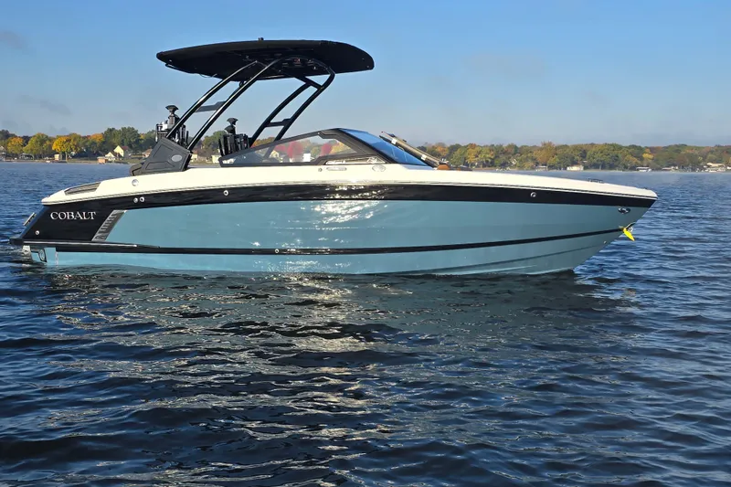 Slide: The Image of 2022 Cobalt R4 Surf boat on a calm lake under clear blue sky. - 10