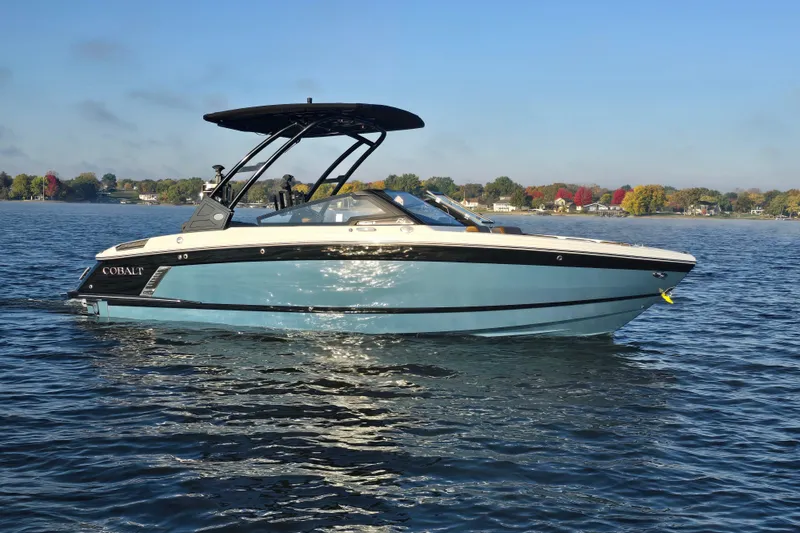 Slide: The Image of 2022 Cobalt R4 Surf boat on a calm lake with scenic shoreline. - 11