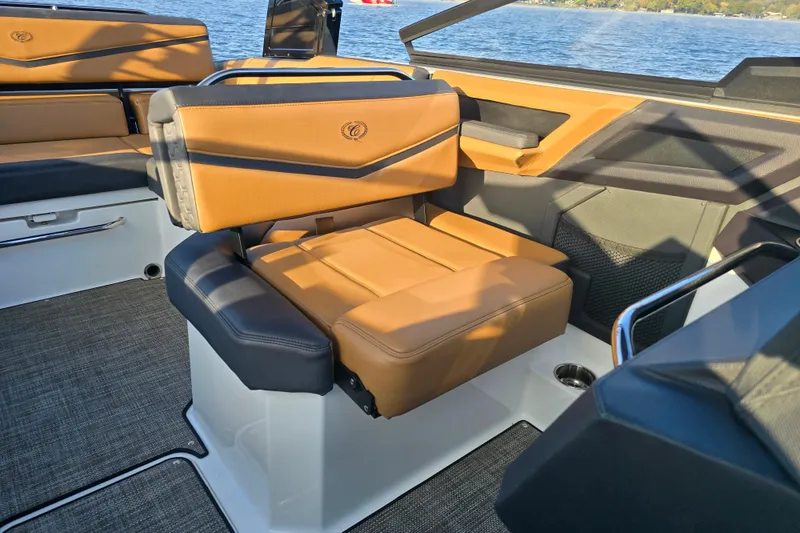 Slide: The Image of 2022 Cobalt R4 Surf boat interior with tan and black seating, on a lake. - 17