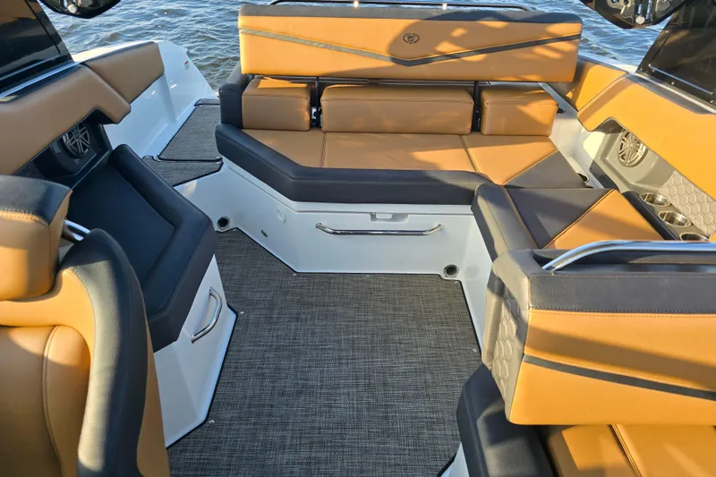 Slide: The Image of 2022 Cobalt R4 Surf boat interior with tan and black seating, on water. - 19