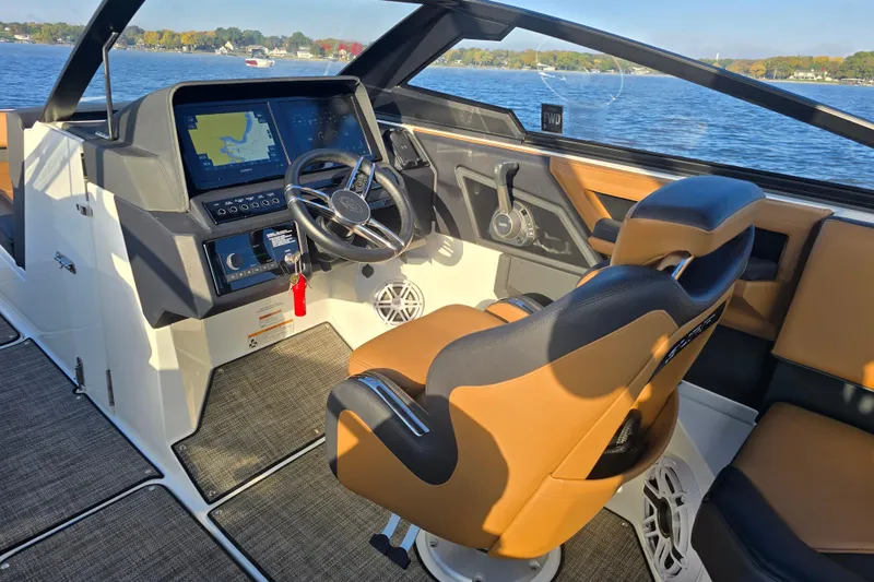 Slide: The Image of 2022 Cobalt R4 Surf boat interior with modern dashboard and steering wheel on a sunny day. - 23