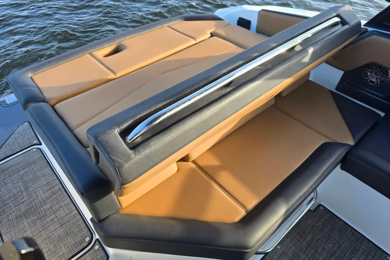 Slide: The Image of 2022 Cobalt R4 Surf boat with tan and black seating, near water. - 27
