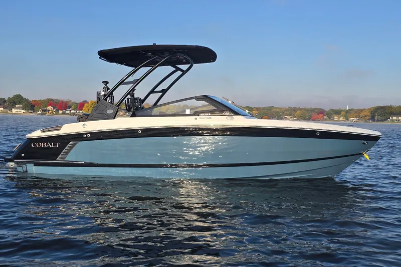 Slide: The Image of 2022 Cobalt R4 Surf boat on a lake with autumn trees in the background. - 29