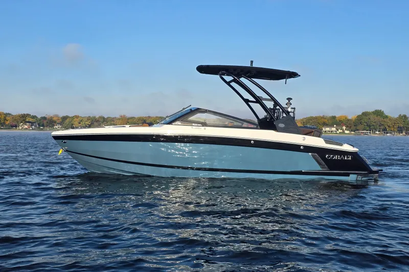 Slide: The Image of 2022 Cobalt R4 Surf boat on a calm lake under a clear blue sky. - 3
