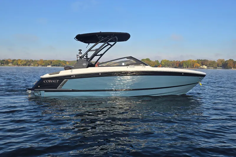 Slide: The Image of 2022 Cobalt R4 Surf boat on calm lake with scenic background. - 31