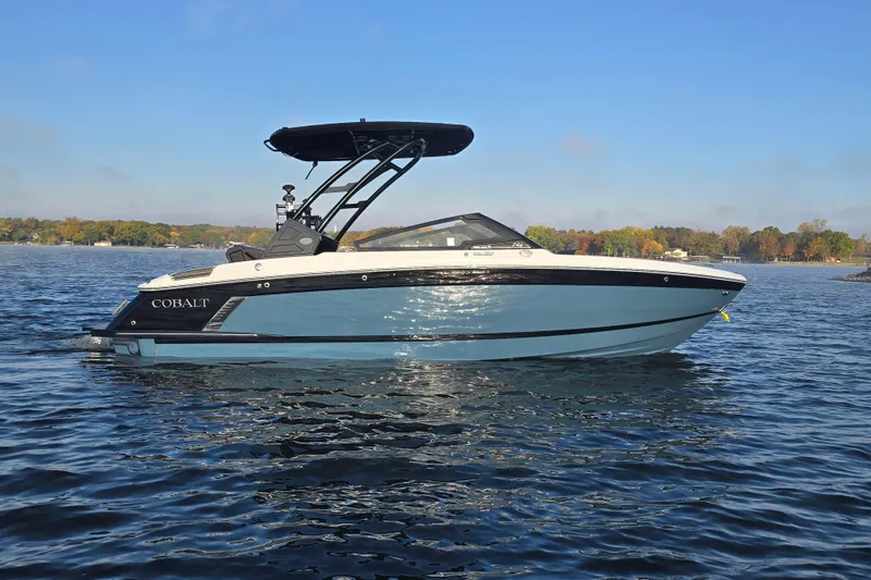 Slide: The Image of 2022 Cobalt R4 Surf boat on a calm lake under a clear blue sky. - 32