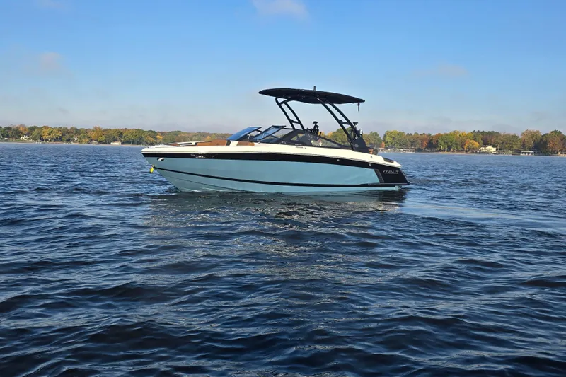 Slide: The Image of 2022 Cobalt R4 Surf boat on a calm lake under a clear blue sky. - 37