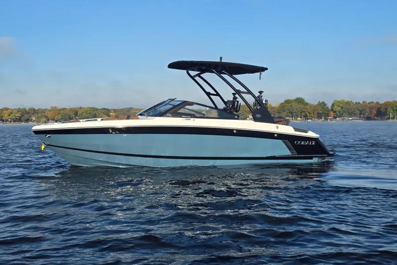 Slide: The Image of 2022 Cobalt R4 Surf boat on a calm lake under a clear blue sky. - 38