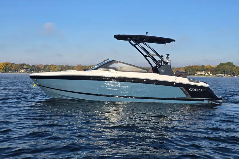 Slide: The Image of 2022 Cobalt R4 Surf boat on a calm lake under clear blue sky. - 4