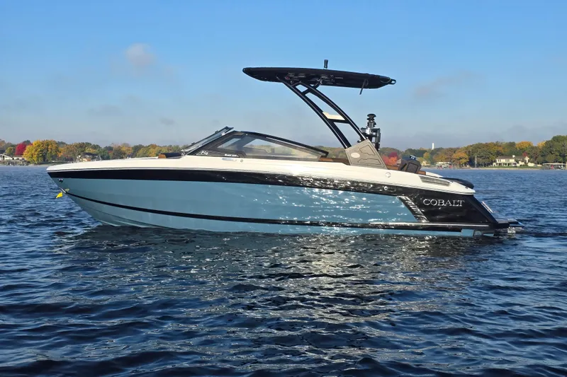 Slide: The Image of 2022 Cobalt R4 Surf boat on a lake with autumn trees in the background. - 6